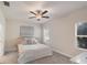 Cozy bedroom features soft carpet, a ceiling fan, and a window with sun-filtering blinds, creating a relaxing ambiance at 12710 Coastal Breeze Way, Bradenton, FL 34211