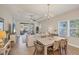 Bright dining area showcasing a modern chandelier, rattan chairs, and seamless flow to the screened lanai at 12710 Coastal Breeze Way, Bradenton, FL 34211