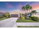Charming single-story home featuring a well-manicured lawn, mature palm trees, and a two-car garage at 12710 Coastal Breeze Way, Bradenton, FL 34211
