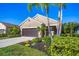 Charming one-story home featuring a well-manicured lawn and attractive landscaping in a tropical style at 12710 Coastal Breeze Way, Bradenton, FL 34211