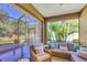 Inviting screened-in patio with wicker furniture and decorative pillows, perfect for outdoor relaxation at 12710 Coastal Breeze Way, Bradenton, FL 34211