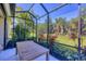 Beautiful screened-in patio with dining table and view of the meticulously maintained lawn and garden at 12710 Coastal Breeze Way, Bradenton, FL 34211