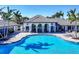 Resort-style pool area with ample seating and palm trees casting shadows on the water at 12710 Coastal Breeze Way, Bradenton, FL 34211