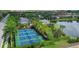 Aerial view of tennis courts surrounded by lush green landscaping and a scenic pond at 12710 Coastal Breeze Way, Bradenton, FL 34211