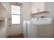 Bright laundry room with washer, dryer, shelving, and door to the outside at 1315 Bottlebrush Dr, Bradenton, FL 34208