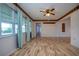 Bright living room with wood floors, ceiling fan, and large windows offering plenty of natural light at 1315 Bottlebrush Dr, Bradenton, FL 34208