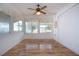 Inviting sunroom features wood-look flooring, fan and windows with valances filling the space with natural light at 1315 Bottlebrush Dr, Bradenton, FL 34208