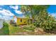 Bright backyard featuring mature trees, a garden bed, and a swing set, perfect for outdoor living and relaxation at 13492 Dibella Ave, Port Charlotte, FL 33981