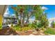 Inviting backyard with stone path, mature trees, garden, and screened lanai offering a serene outdoor space at 13492 Dibella Ave, Port Charlotte, FL 33981