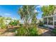 Lush backyard featuring a palm tree, garden beds, and the house in the background at 13492 Dibella Ave, Port Charlotte, FL 33981