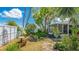 Serene backyard oasis with lush garden, mature trees, and charming screened-in porch offering a peaceful outdoor retreat at 13492 Dibella Ave, Port Charlotte, FL 33981