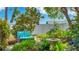 Tranquil backyard retreat with cozy bench, mature trees, lush foliage, and bird bath for peaceful relaxation at 13492 Dibella Ave, Port Charlotte, FL 33981