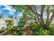 Lush backyard with mature shade trees, a bird bath, and a bench, creating a peaceful outdoor oasis at 13492 Dibella Ave, Port Charlotte, FL 33981