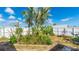 Backyard oasis with a palm tree, landscaped garden beds, and a white privacy fence at 13492 Dibella Ave, Port Charlotte, FL 33981