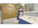 Bathroom boasts stylish blue vanity, patterned wallpaper, and tub with shower at 13492 Dibella Ave, Port Charlotte, FL 33981