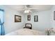 Bright bedroom featuring light blue walls, a ceiling fan, and framed artwork for a personal touch at 13492 Dibella Ave, Port Charlotte, FL 33981
