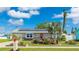 Charming single-story home features a vibrant red door, solar panels, and a beautifully landscaped front yard at 13492 Dibella Ave, Port Charlotte, FL 33981