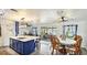Bright, updated kitchen with blue island and modern lighting, flowing to a dining area with outdoor views at 13492 Dibella Ave, Port Charlotte, FL 33981