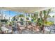Bright sunroom with tile flooring, lots of windows, and comfortable seating amidst potted plants at 13492 Dibella Ave, Port Charlotte, FL 33981