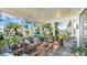 Cozy sunroom with tile floor, surrounded by potted plants and comfortable seating at 13492 Dibella Ave, Port Charlotte, FL 33981