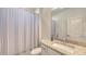 Bright bathroom featuring a sink with granite countertop, a large mirror, and a shower with a striped curtain at 15332 Serene Shores Loop St, Bradenton, FL 34211