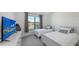 Inviting bedroom featuring two twin beds, a large window with curtains, and a modern dresser with a TV at 15332 Serene Shores Loop St, Bradenton, FL 34211