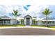 Front exterior view of the pristine clubhouse featuring palm trees and a well-manicured lawn at 15332 Serene Shores Loop St, Bradenton, FL 34211