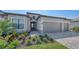Exterior of gray home with stone veneer accents and a paved driveway, featuring a well-maintained lawn at 15332 Serene Shores Loop St, Bradenton, FL 34211