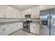 Modern kitchen with stainless steel appliances, white cabinets, and granite countertops at 15332 Serene Shores Loop St, Bradenton, FL 34211