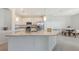 Bright kitchen featuring a large granite island, white cabinetry, and stainless steel appliances at 15332 Serene Shores Loop St, Bradenton, FL 34211