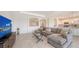 Comfortable living room with gray sectional sofa, modern TV console, and arched room accents at 15332 Serene Shores Loop St, Bradenton, FL 34211