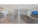 Open-concept living space with tile floors, gray sectional sofa, and a modern kitchen at 15332 Serene Shores Loop St, Bradenton, FL 34211