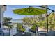 Back porch with a waterfront view, shaded seating under an umbrella, and a glimpse of the pool at 1540 Hillview Dr, Sarasota, FL 34239