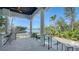 Covered porch with waterfront view featuring outdoor bar, seating area, and steps down to a pool at 1540 Hillview Dr, Sarasota, FL 34239