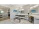 Bright modern primary bathroom with double vanity, illuminated mirrors, television, and access to the shower area at 1540 Hillview Dr, Sarasota, FL 34239