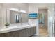 Modern bathroom with sleek vanity, decorative mirror, television, and a view to the shower area at 1540 Hillview Dr, Sarasota, FL 34239