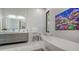 Bright bathroom featuring double sinks, modern fixtures, a soaking tub, and stylish artwork for a spa-like experience at 1540 Hillview Dr, Sarasota, FL 34239
