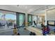 Bright home gym featuring a fireplace, mirrors, and glass doors with scenic water views for a complete fitness experience at 1540 Hillview Dr, Sarasota, FL 34239