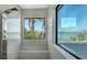 Modern shower featuring luxurious fixtures and scenic views of the water and palm trees from the large windows at 1540 Hillview Dr, Sarasota, FL 34239