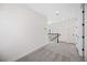 This brightly lit hallway features gray carpeting and a modern black metal railing at 164 Eagleston Ln, Sarasota, FL 34240