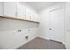 Well-lit laundry room features upper cabinets, modern flooring, and washer/dryer hookups at 164 Eagleston Ln, Sarasota, FL 34240