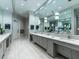 A modern bathroom boasts multiple sinks with vanity mirrors and contemporary fixtures at 17118 Vardon Ter # 101, Bradenton, FL 34211