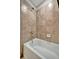 Modern bathtub with tile surround and a showerhead at 17118 Vardon Ter # 101, Bradenton, FL 34211