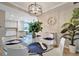 Dining room featuring a modern chandelier, glass table, white chairs, and a nearby plant at 17118 Vardon Ter # 101, Bradenton, FL 34211