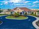 Exterior shot of a landscaped, luxurious community building with circular driveway at 17118 Vardon Ter # 101, Bradenton, FL 34211
