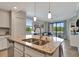 Open-concept kitchen featuring granite countertops, stainless steel appliances, and island with pendant lighting at 17118 Vardon Ter # 101, Bradenton, FL 34211