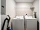 A laundry room features a washer and dryer with wire rack shelving at 17118 Vardon Ter # 101, Bradenton, FL 34211