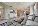 Comfortable living room with a gray sectional, TV, and an open view into the kitchen at 17118 Vardon Ter # 101, Bradenton, FL 34211