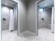 Modern community showers with gray tile, white curtains, and convenient wall-mounted soap dispensers at 17118 Vardon Ter # 101, Bradenton, FL 34211