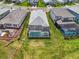 An aerial view shows backyard with pool, green lawn, and a defined property line amidst neighboring houses at 17502 Savory Mist Cir, Bradenton, FL 34211